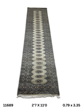 Handmade wool and cotton area rug or runner with repeated geometric Bokhara pattern displayed on floor