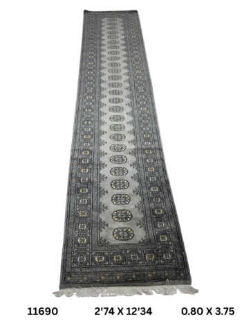 Handmade wool and cotton area rug or runner with repeated geometric Bokhara pattern displayed on floor