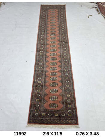 Handmade wool and cotton area rug or runner with repeated geometric Bokhara pattern displayed on floor