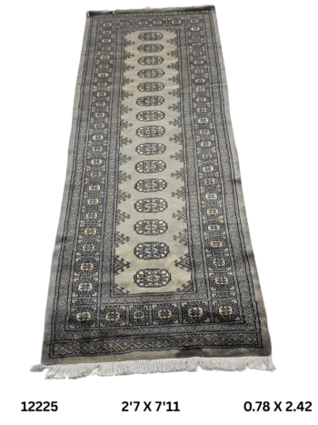 Handmade wool and cotton area rug or runner with repeated geometric Bokhara pattern displayed on floor