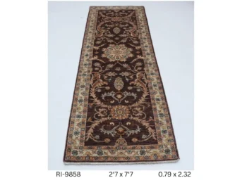 Handmade wool and cotton area rug or runner with classic floral Heriz pattern displayed on floor
