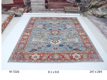 Handmade wool and cotton area rug or runner with classic floral Heriz pattern displayed on floor